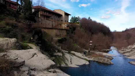 Sideways-drone-flight-over-some-stones-and-a-waterfall-at-daytime