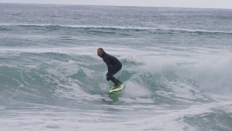 un talentoso surfista masculino bombea su ola con altas habilidades, playa de surf unstad, islas lofoten, noruega