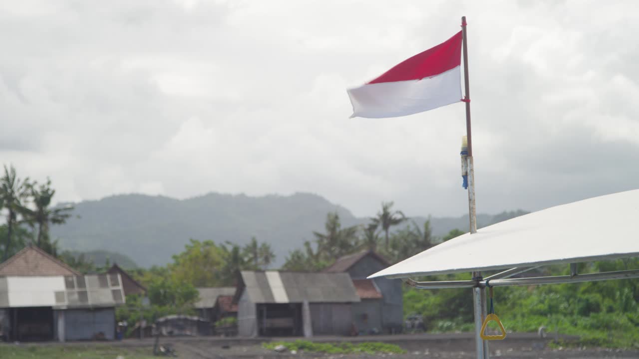 Indonesian flag blowing in the wind on the coast of Bali
