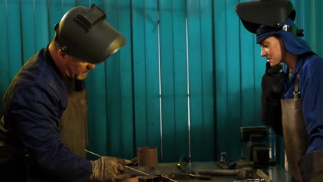soldadora inclinada en el taller
