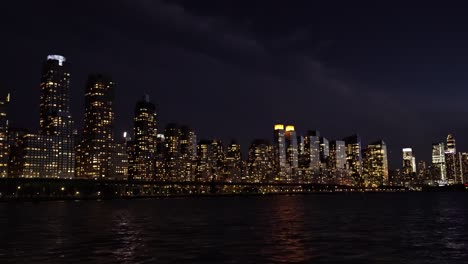 majestic skyline of new york city at night with glowing building lights from hudson river