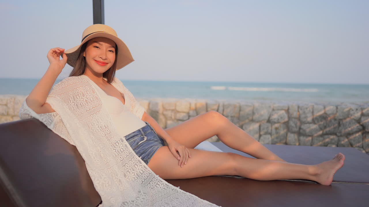 여행, 여름, 개념 - 해변 근처의 이국적인 리조트에서 휴식을 취하는 서양식 옷을 입은 아름다운 젊은 여성