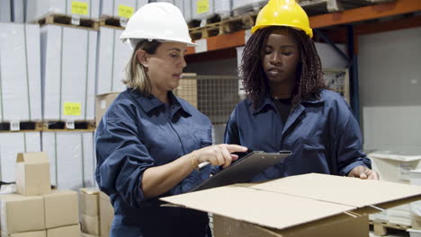 travailleuses d'une entreprise de logistique parlant dans un entrepôt