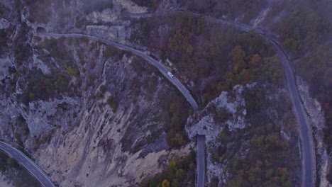 Camión-Grande-Conduciendo-Por-Una-Pequeña-Carretera-De-Montaña-A-Través-Del-Túnel-En-El-Lago-Piva-Montenegro,-Aéreo