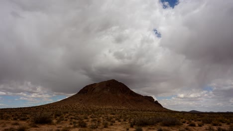 nuvens sombreiam uma montanha cônica no deserto de mojave - lapso de tempo estacionário