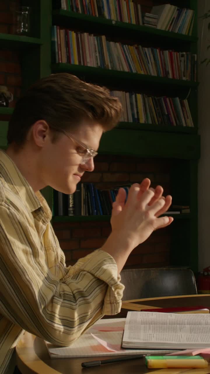 joven estudiando en una habitación con libros