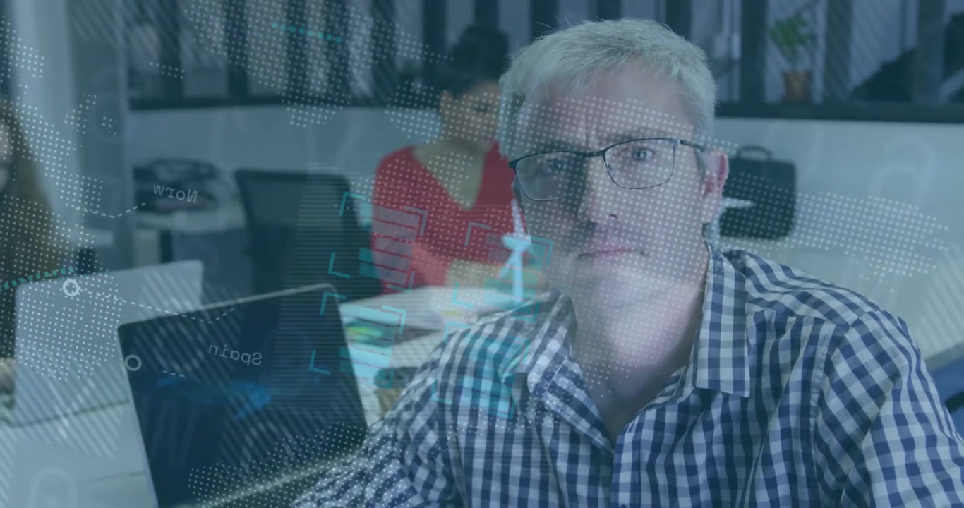 Mann sitzt am Schreibtisch, Laptop erzeugt Globus-Overlay, das über Kollegen fegt und Geschäftsdaten anzeigt.