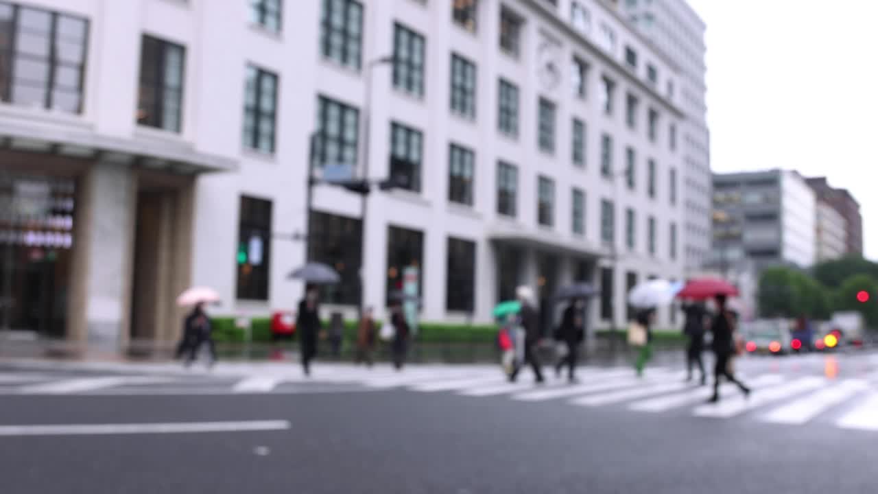 Walking people on the street in Marunouchi Tokyo rainy day