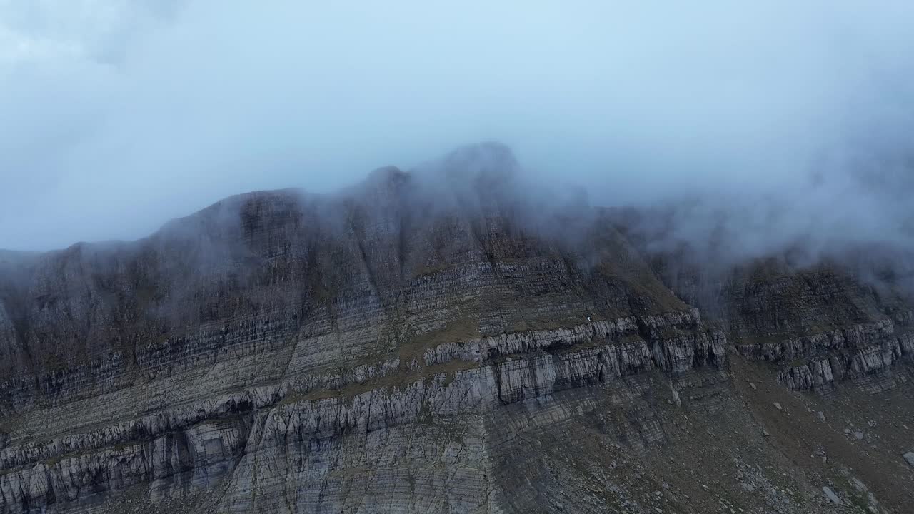 Pico tortiellas summit shrouded in mist near canfranc-estación in aragón, spain, aerial view