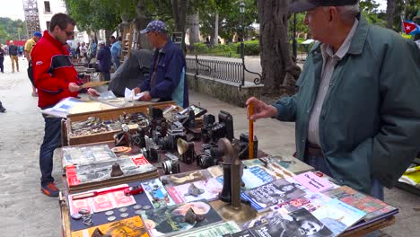 vendors on the streets of havana cuba sell old cameras radios and propaganda books and posters