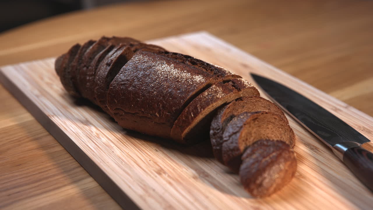 Sliced rye bread on a cutting board with knife