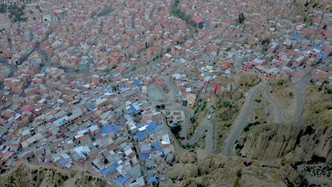 Hairpin-roads-dot-the-cityscape-in-this-scenic-aerial-drone-tilt-down-view-of-La-Paz,-Bolivia