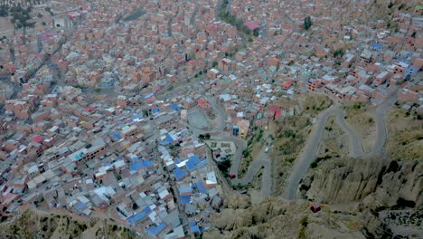 hairpin roads dot the cityscape in this scenic aerial drone tilt down view of la paz, bolivia