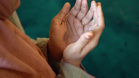 a woman praying with hands raised in prayer