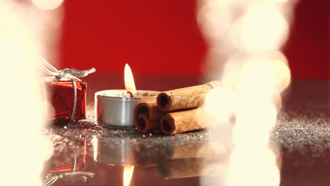 vista de la vela ardiendo junto al pequeño regalo de navidad
