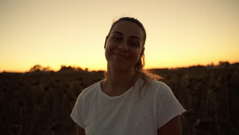 Close-up-of-one-lovely-young-girl-softly-smiling-at-camera-in-the-park-after-sunset-night,-attractive-young-girl-smile-at-her-boyfriend-camera,-beautiful-young-woman-footage