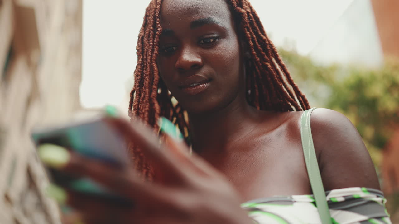 Donna afroamericana che usa un telefono
