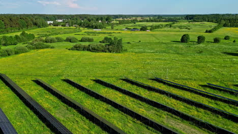 Green-meadow-and-solar-panel-farm,-aerial-drone-view