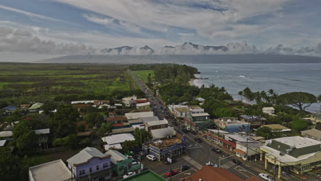 Paia-Maui-Hawaii-Aerial-v4-drone-flyover-town-center-along-coastal-Hana-highway-capturing-picturesque-townscape-and-West-Maui-Volcano-mountains-on-the-skyline---Shot-with-Mavic-3-Cine---December-2022