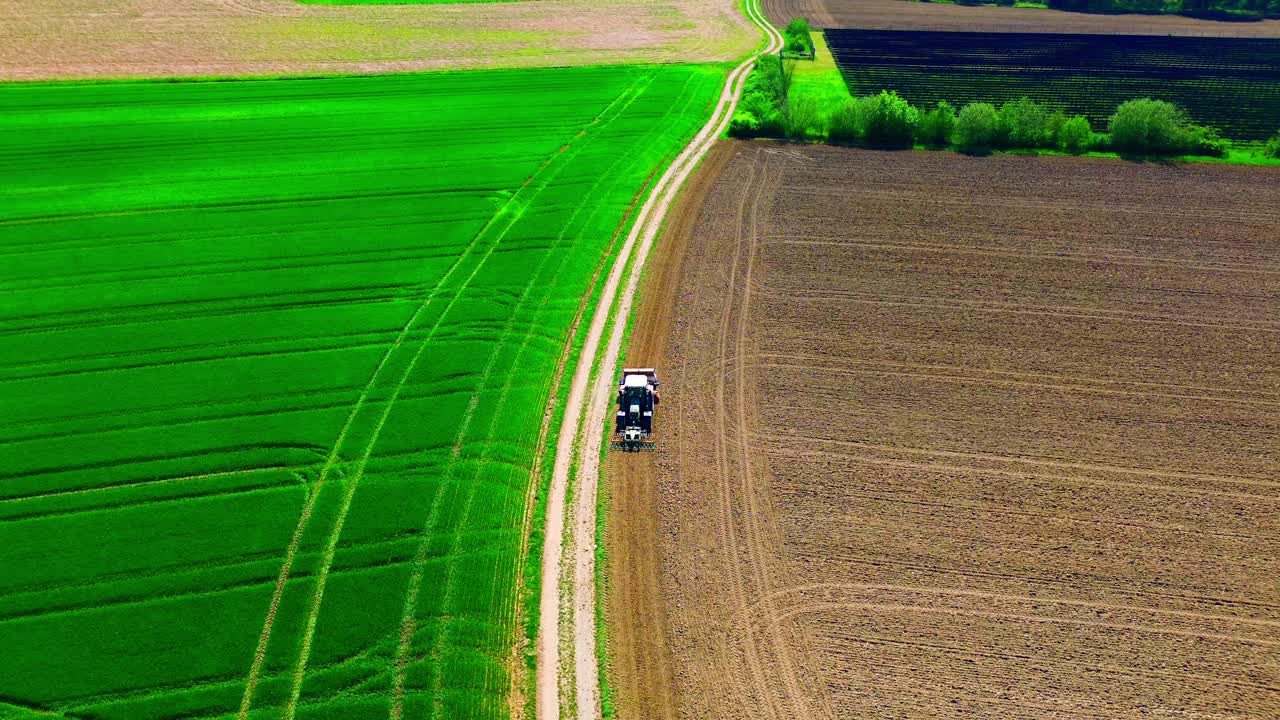 시골 에서 초록색 과 갈색 의 농지 사이 를 운전 하는 트랙터 의 공중 사진