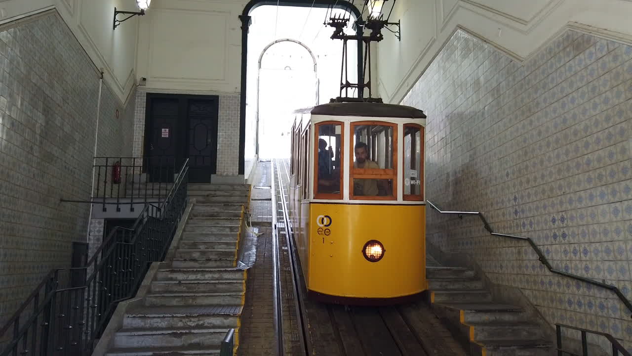 Static medium view of iconic yellow Tram 28 passing through Alfama, Lisbon, Portugal