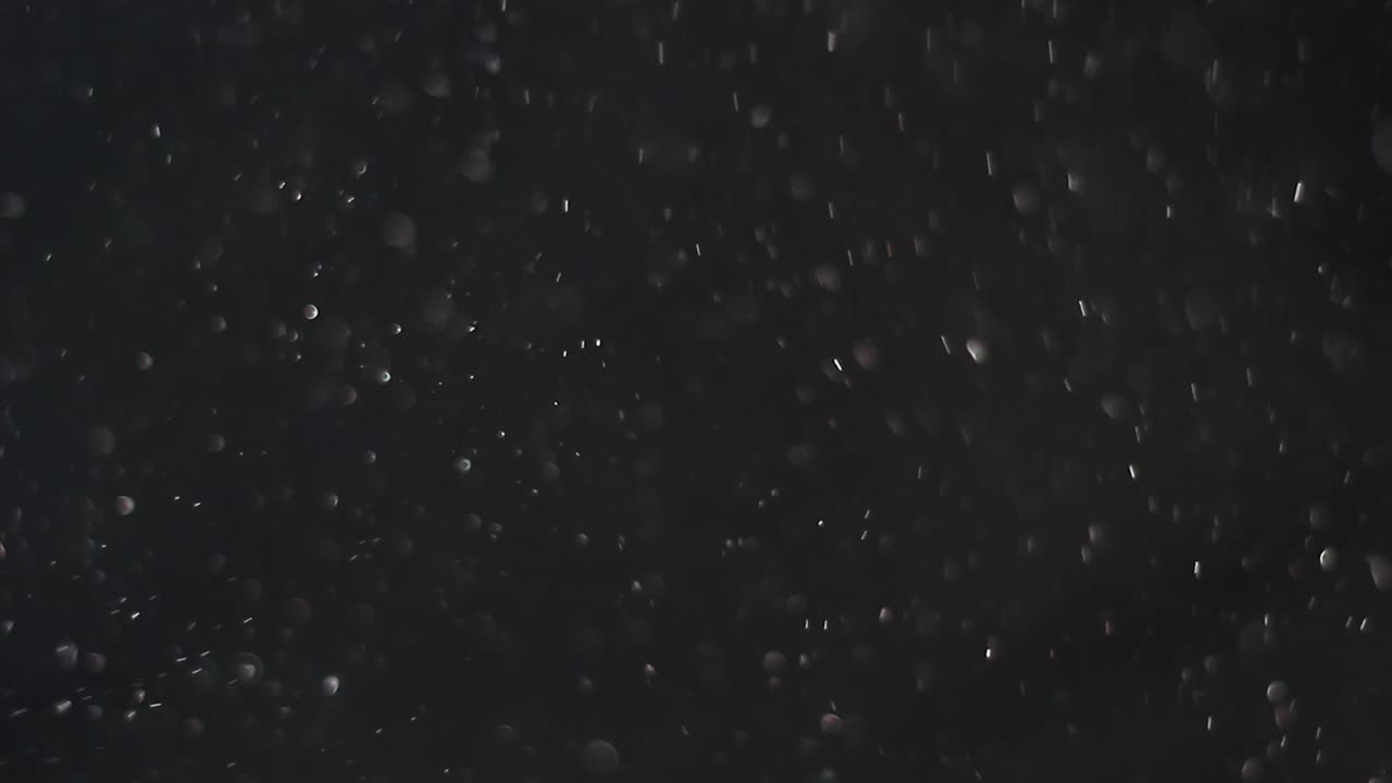 검은 배경 에 먼지 가 회전 하고 있다