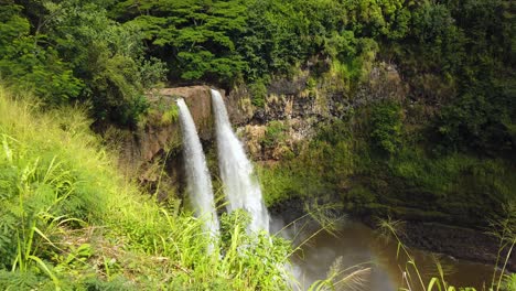 4k hawaii kauai boom up with tall grass in foreground to reveal more of wailua falls in background