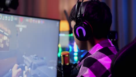 nahaufsicht auf den asiatischen streamer-jungen, der tor schreit und tanzt, der das gewinnspiel über das netzwerk auf einem personalcomputer feiert. live-stream-videospiel, schreibtisch beleuchtet durch rgb-led-strip-licht
