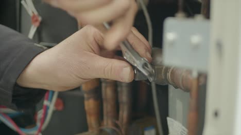 idraulic technician using screwdriver to repair damaged pipe