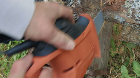 man sawing the wood with electric tool