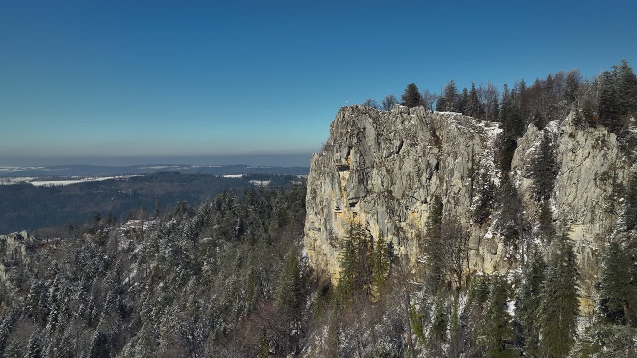밝고 화창한 겨울날 눈으로 뒤덮인 쥐라 스위스의 거대한 생 브라이스 바위