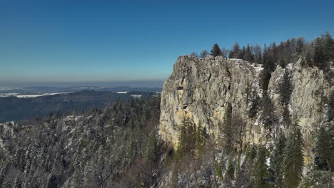 huge saint-brais rock in the jura switzerland covered with snow on a bright sunny winter day