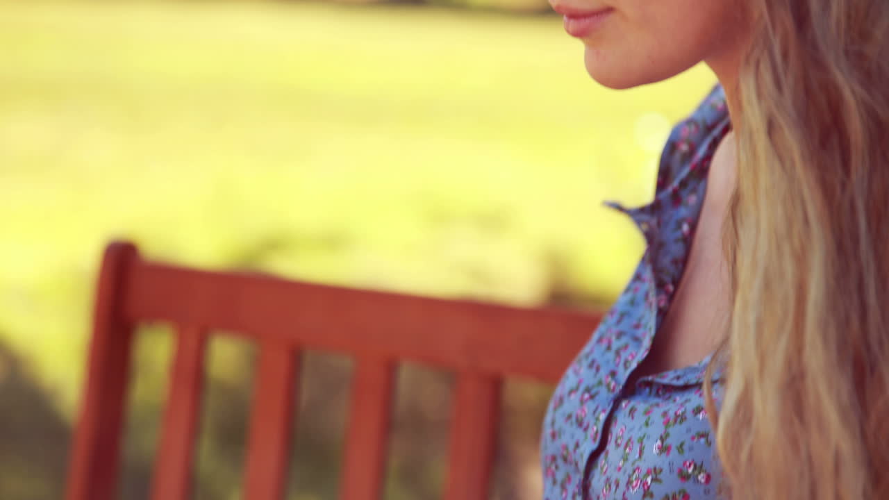 높은 품질의 4k 형식으로 공원에서 노트북을 사용하는 예쁜 금발