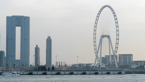 Yate-De-Lujo-Navegando-Frente-A-La-Noria-Y-El-Paisaje-Urbano-De-Ain-Dubai