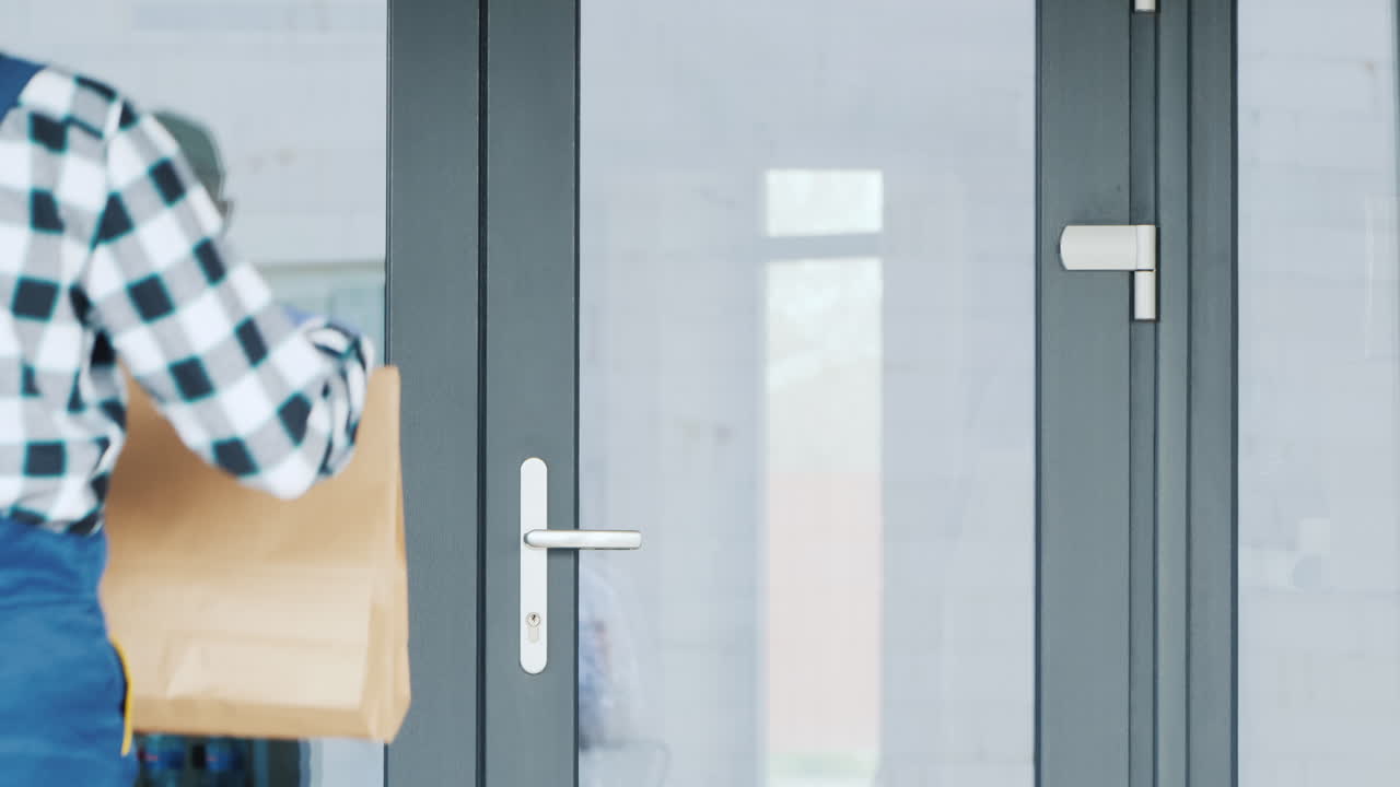 un mensajero con una máscara y guantes entrega comida a la puerta del cliente