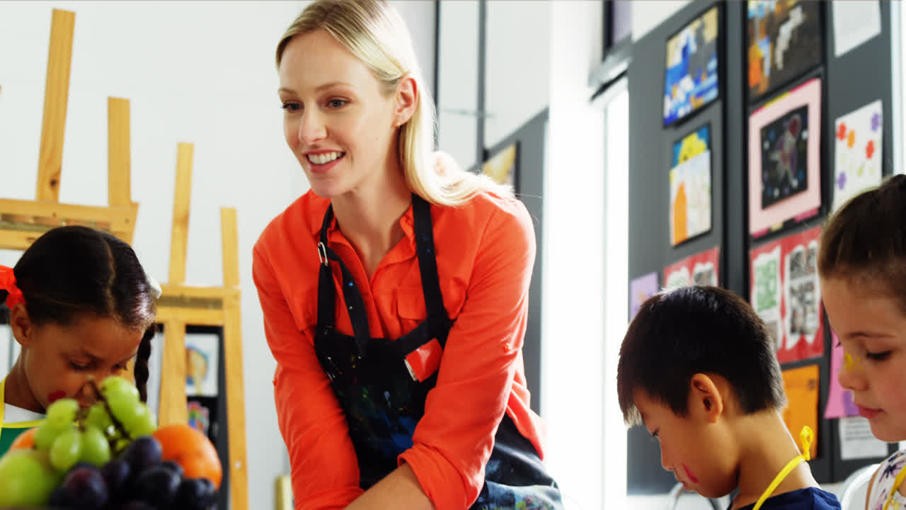 Teacher assisting schoolkid in drawing class