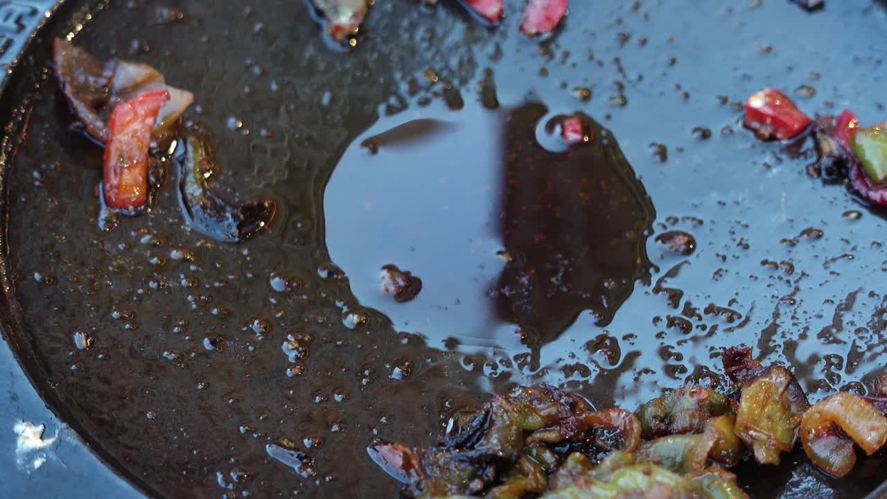 sartén de parrilla sucia con verduras y aceite sobrantes