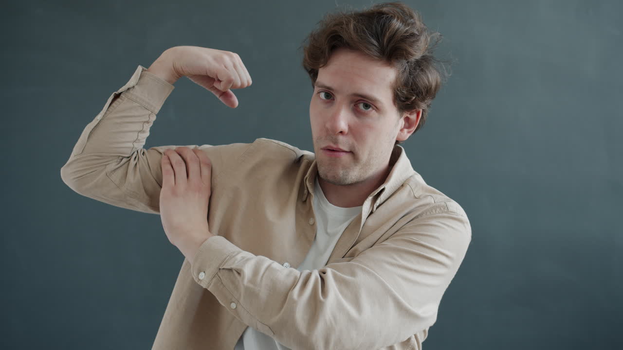 Man in a beige shirt gesturing