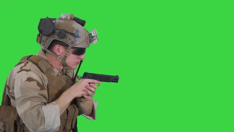 soldier aiming and shooting with a pistol on a green screen, chroma key