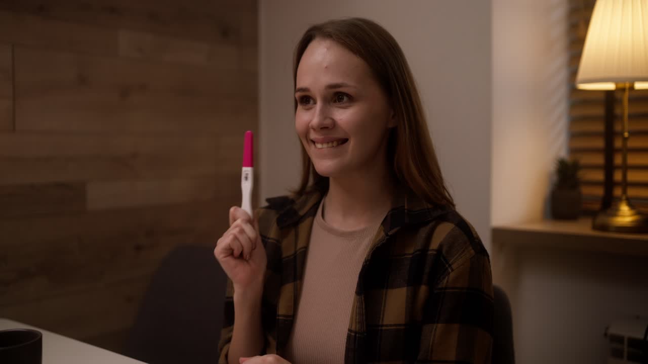 mujer feliz sosteniendo una prueba de embarazo