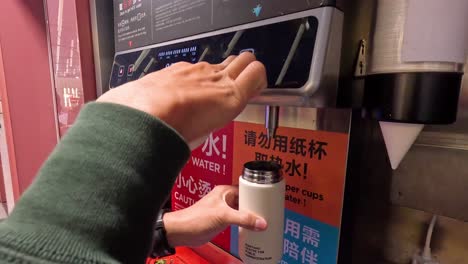 person operating a hot water dispenser