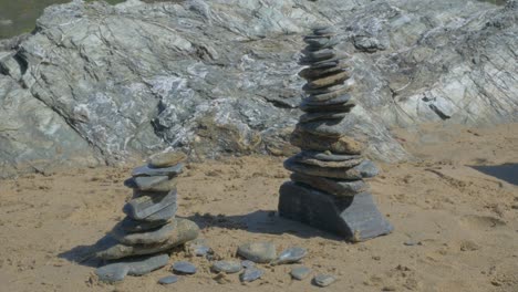 rock stacking on sandy beach blue slate