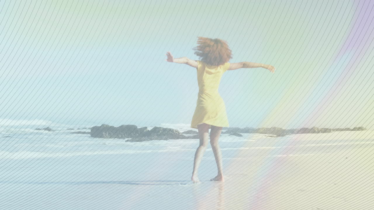 Spinning joyfully, woman in yellow dress with rainbow animation on beach
