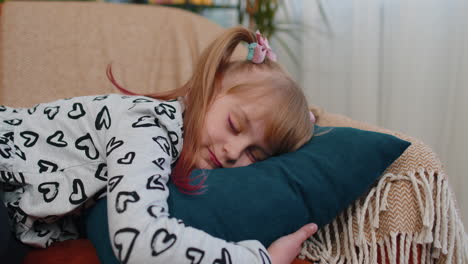 little teen children girl sleeping, resting, enjoying carefree peaceful weekend, on couch at home