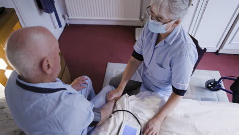 nurse checking elderly man's blood pressure