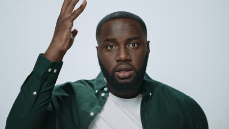 portrait of stressed african american man touching head with hands in studio.