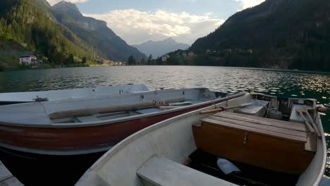 boats floating on the shore of lake alleghe