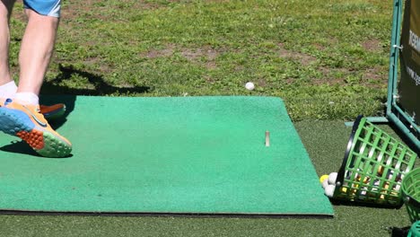 persona practicando el swing de golf en la alfombra verde