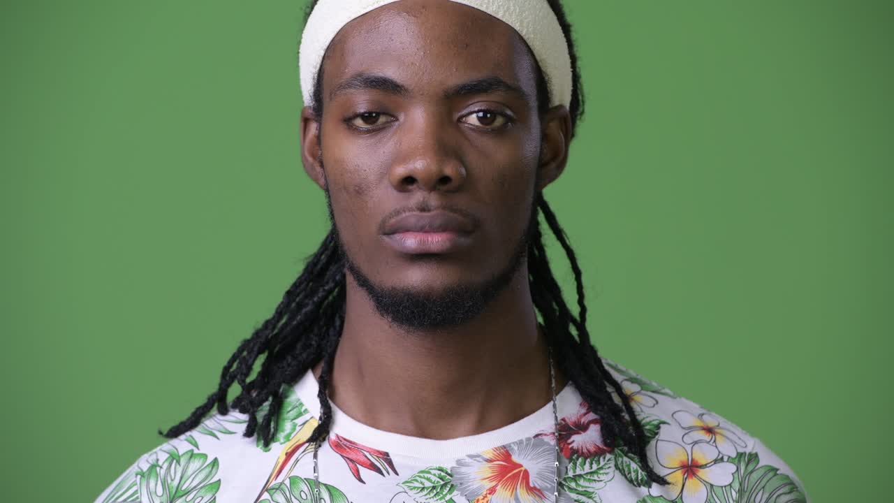 초록색 배경 에 드레드 머리카락 을 가진 젊은 잘생긴 아프리카인