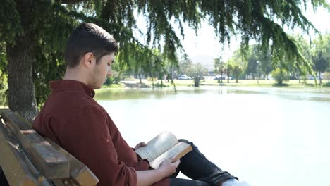 man sitting and reading book in river